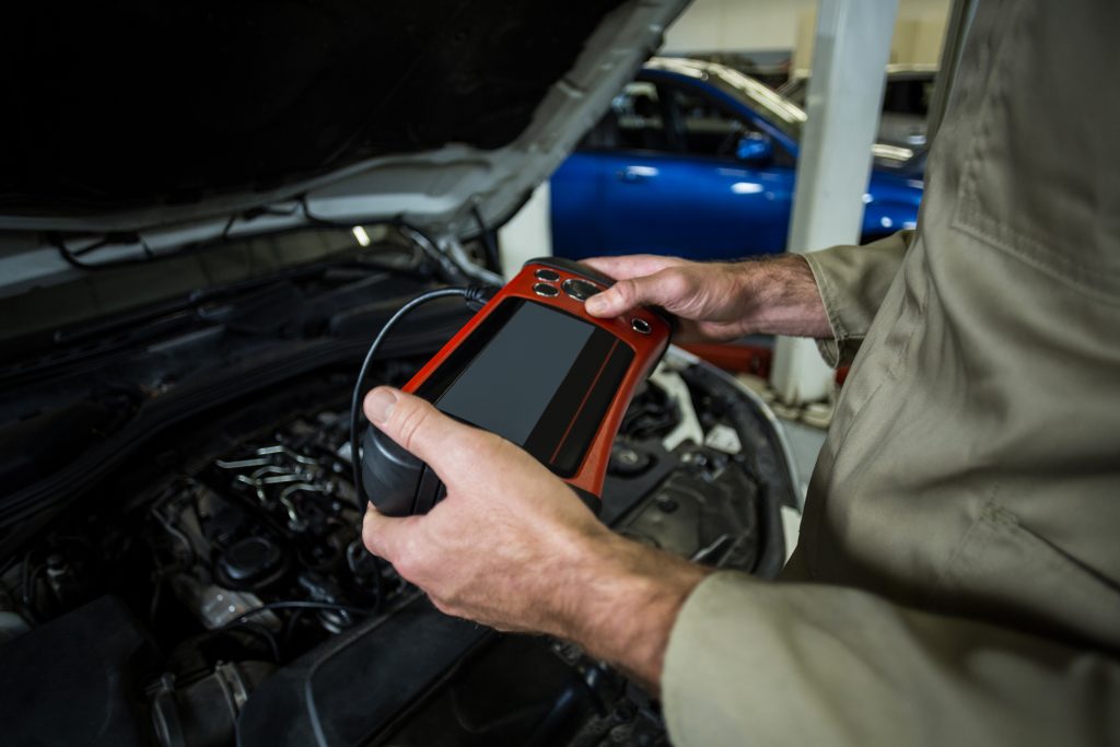 Signs your car key is failing as a professional auto locksmith inspects a damaged car key and faulty key fob in the UK